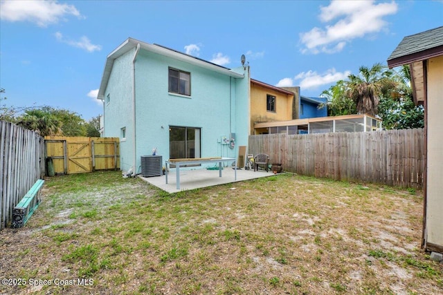 rear view of property featuring a patio, a fenced backyard, a gate, a yard, and stucco siding