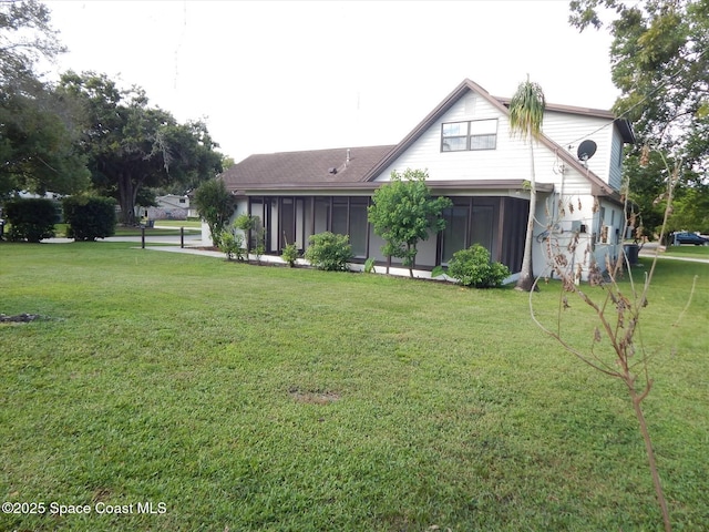 back of house with a yard and a sunroom