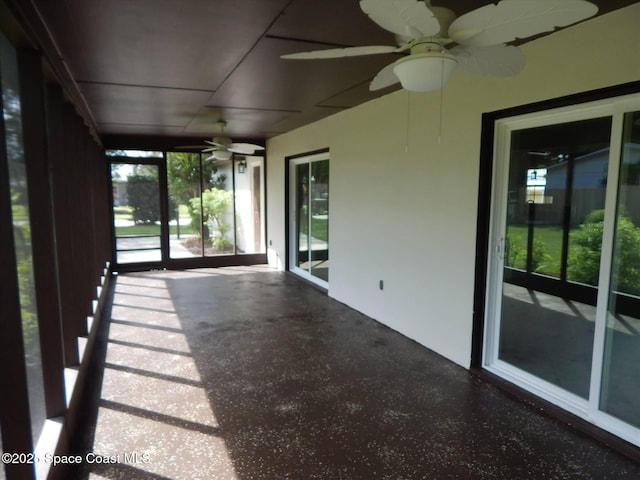 unfurnished sunroom with ceiling fan