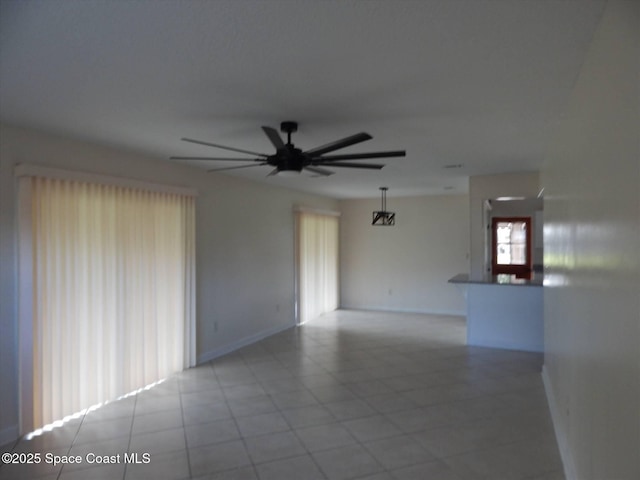 tiled empty room featuring ceiling fan