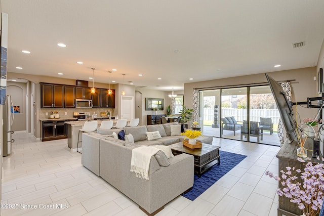 living room featuring a chandelier and light tile patterned flooring