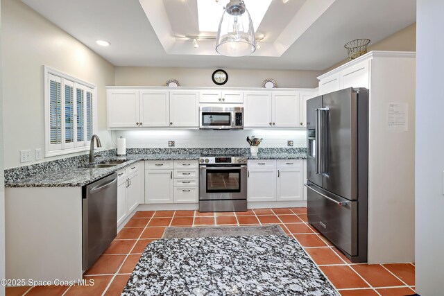 kitchen featuring tile patterned floors, sink, stainless steel appliances, light stone countertops, and white cabinets