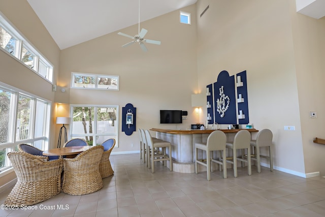 dining space featuring ceiling fan, high vaulted ceiling, and light tile patterned floors