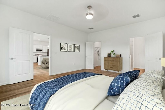 bedroom featuring a spacious closet and hardwood / wood-style floors