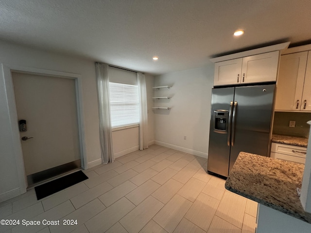 kitchen with white cabinetry, light stone countertops, and stainless steel fridge with ice dispenser