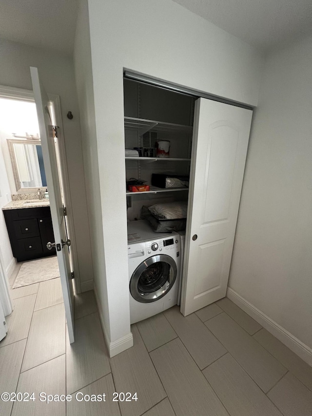 clothes washing area featuring washer / dryer and sink