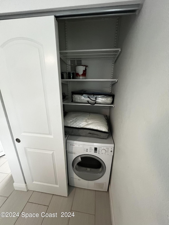 laundry area featuring light tile patterned floors and washer / dryer