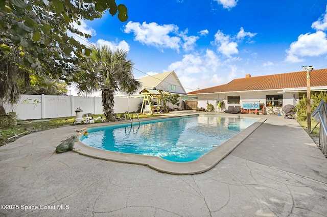 view of swimming pool with a playground and a patio