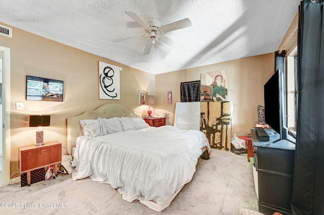 carpeted bedroom featuring vaulted ceiling, ceiling fan, and a textured ceiling