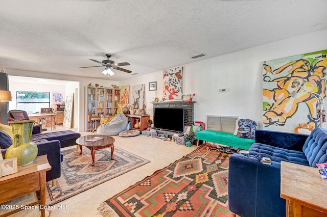 living room with ceiling fan and a textured ceiling