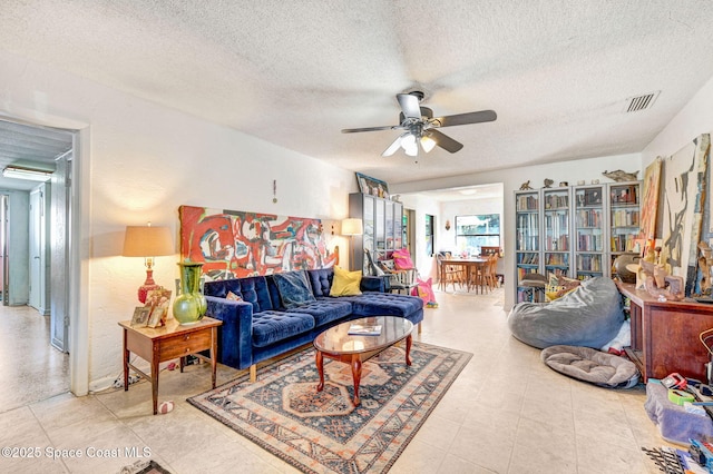 living room with a textured ceiling and ceiling fan