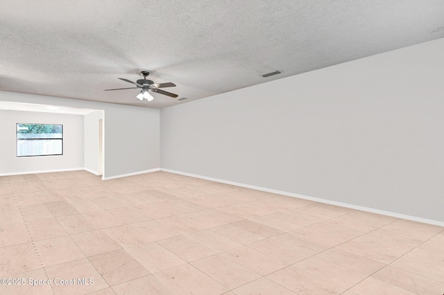 empty room with ceiling fan and a textured ceiling