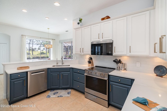 kitchen with blue cabinetry, white cabinets, and appliances with stainless steel finishes