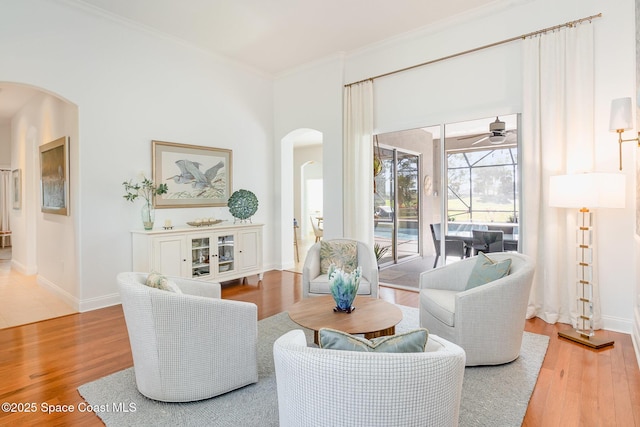 sitting room featuring wood-type flooring, ornamental molding, and ceiling fan