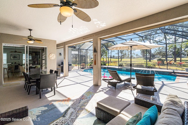 view of patio / terrace featuring an outdoor living space, ceiling fan, and glass enclosure