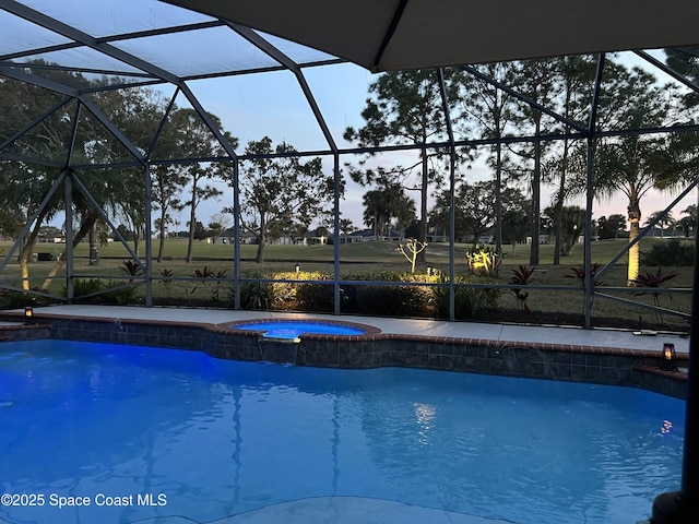 pool at dusk with an in ground hot tub, a lanai, and a patio