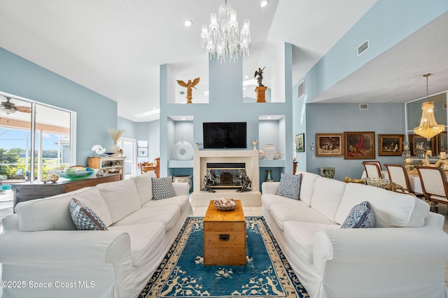 living room featuring a fireplace and ceiling fan with notable chandelier