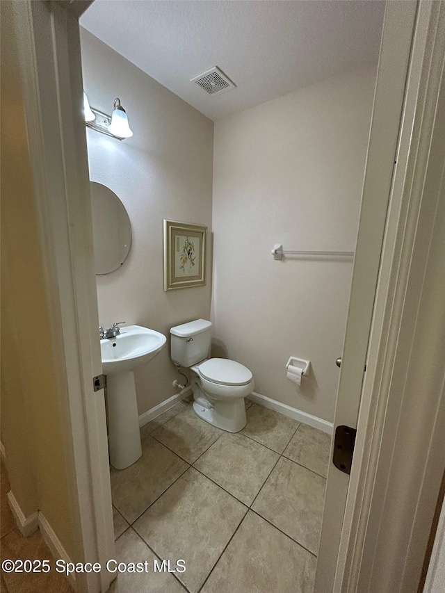 bathroom featuring sink, a textured ceiling, tile patterned floors, and toilet