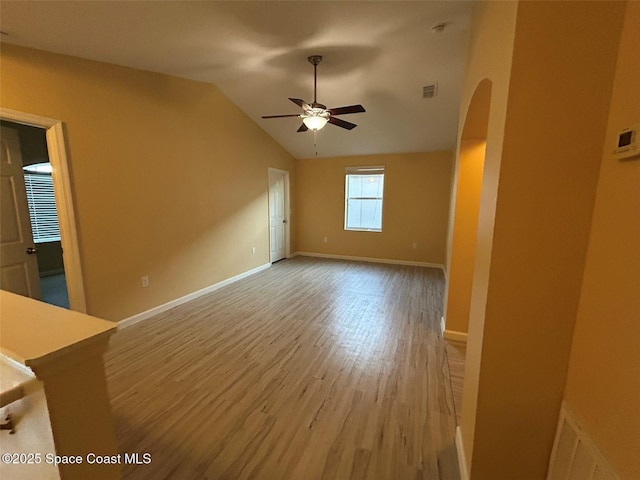 unfurnished living room featuring wood-type flooring, ceiling fan, and vaulted ceiling