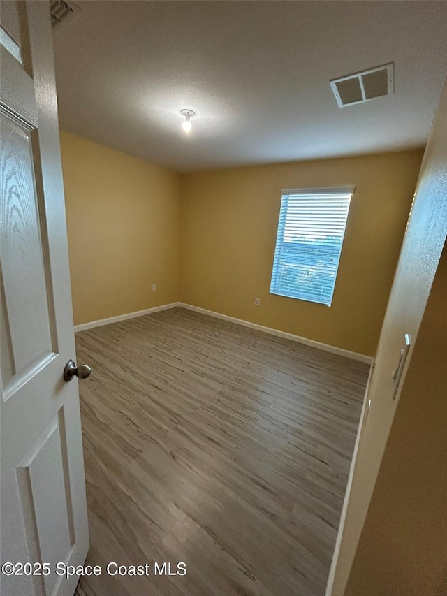 unfurnished room with wood-type flooring