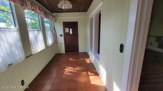 entryway featuring dark tile patterned flooring and wood ceiling