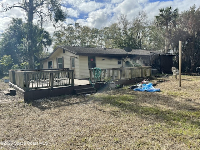 rear view of property with a deck and a lawn