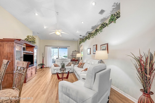 living room with high vaulted ceiling, ceiling fan, and light wood-type flooring