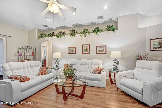 living room featuring ceiling fan, lofted ceiling, and light hardwood / wood-style floors