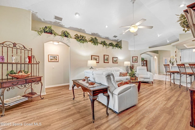 living room with ceiling fan, high vaulted ceiling, and light wood-type flooring