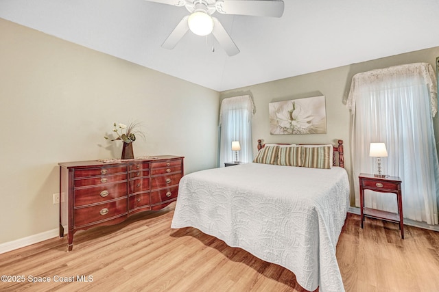 bedroom with vaulted ceiling, ceiling fan, and light hardwood / wood-style flooring