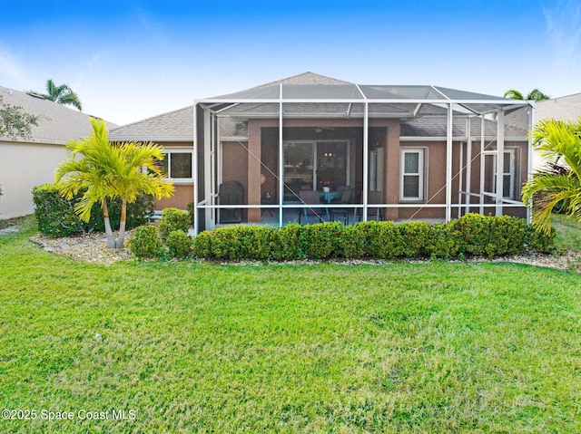 back of house with a yard and a lanai