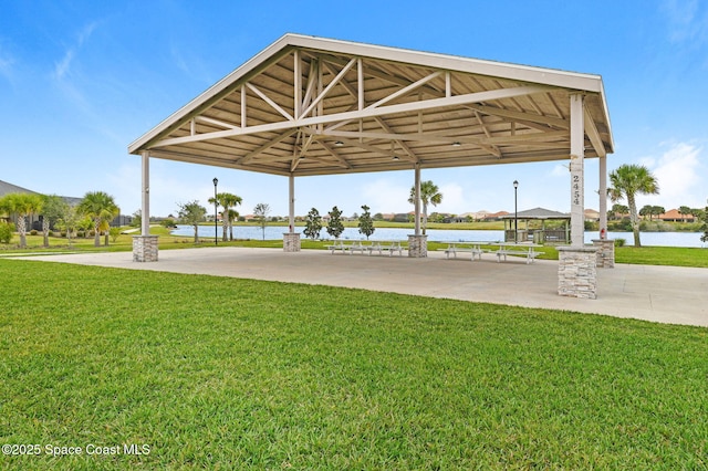 view of property's community with a gazebo, a water view, and a lawn