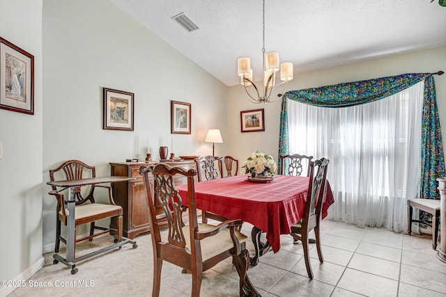 dining space with a notable chandelier, vaulted ceiling, a textured ceiling, and light tile patterned flooring