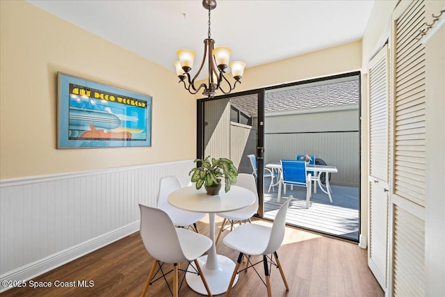 dining area with wood-type flooring and a chandelier