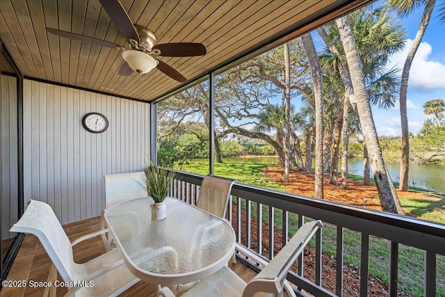 sunroom / solarium with a water view, ceiling fan, and wooden ceiling