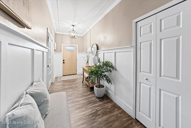 foyer entrance with ornamental molding, a chandelier, and dark hardwood / wood-style flooring