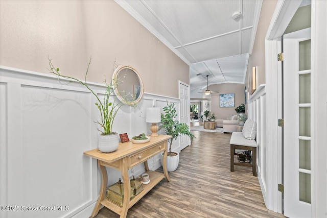 entryway featuring lofted ceiling, crown molding, wood-type flooring, and ceiling fan