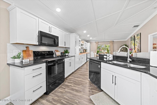 kitchen featuring white cabinetry, hardwood / wood-style flooring, sink, and black appliances