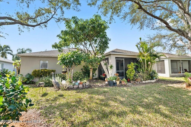 rear view of property featuring a sunroom and a lawn