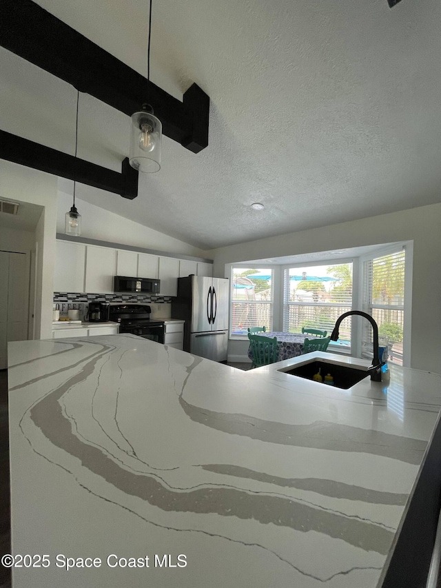 kitchen with sink, vaulted ceiling with beams, white cabinetry, pendant lighting, and black appliances