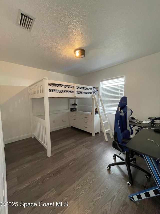 unfurnished bedroom featuring dark wood-type flooring and a textured ceiling