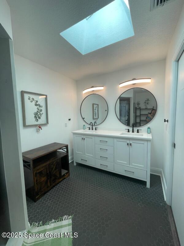 bathroom featuring vanity and a skylight