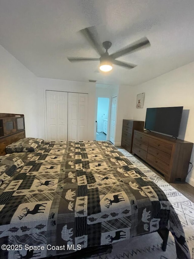 carpeted bedroom featuring ceiling fan, a closet, and a textured ceiling