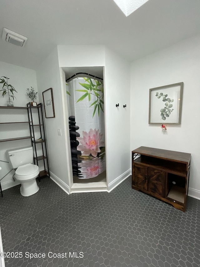 interior space with a shower with curtain and toilet