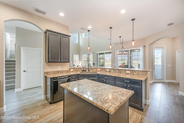 kitchen with hanging light fixtures, kitchen peninsula, black dishwasher, and a kitchen island