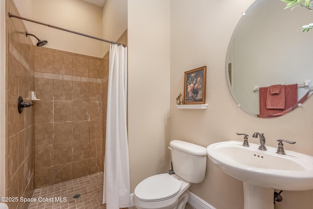 bathroom featuring sink, curtained shower, and toilet