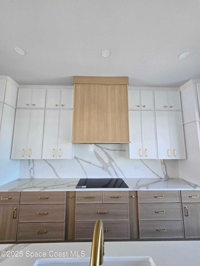 2050 S Atlantic Ave, Cocoa Beach, FL 32931 - kitchen featuring black electric stovetop, white cabinetry, light stone countertops, recessed lighting, and ventilation hood
