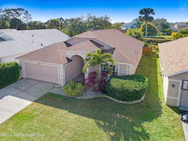 view of front of property with a garage and a front lawn