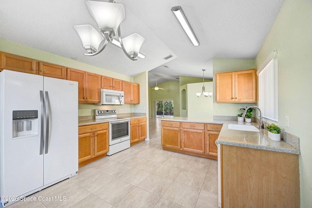 kitchen featuring sink, white appliances, hanging light fixtures, vaulted ceiling, and kitchen peninsula