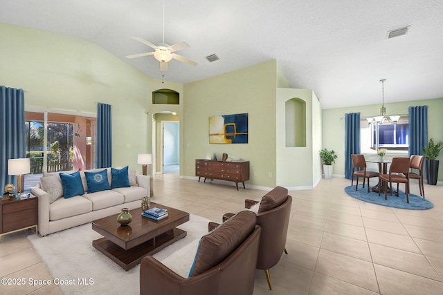 tiled living room featuring ceiling fan with notable chandelier and high vaulted ceiling